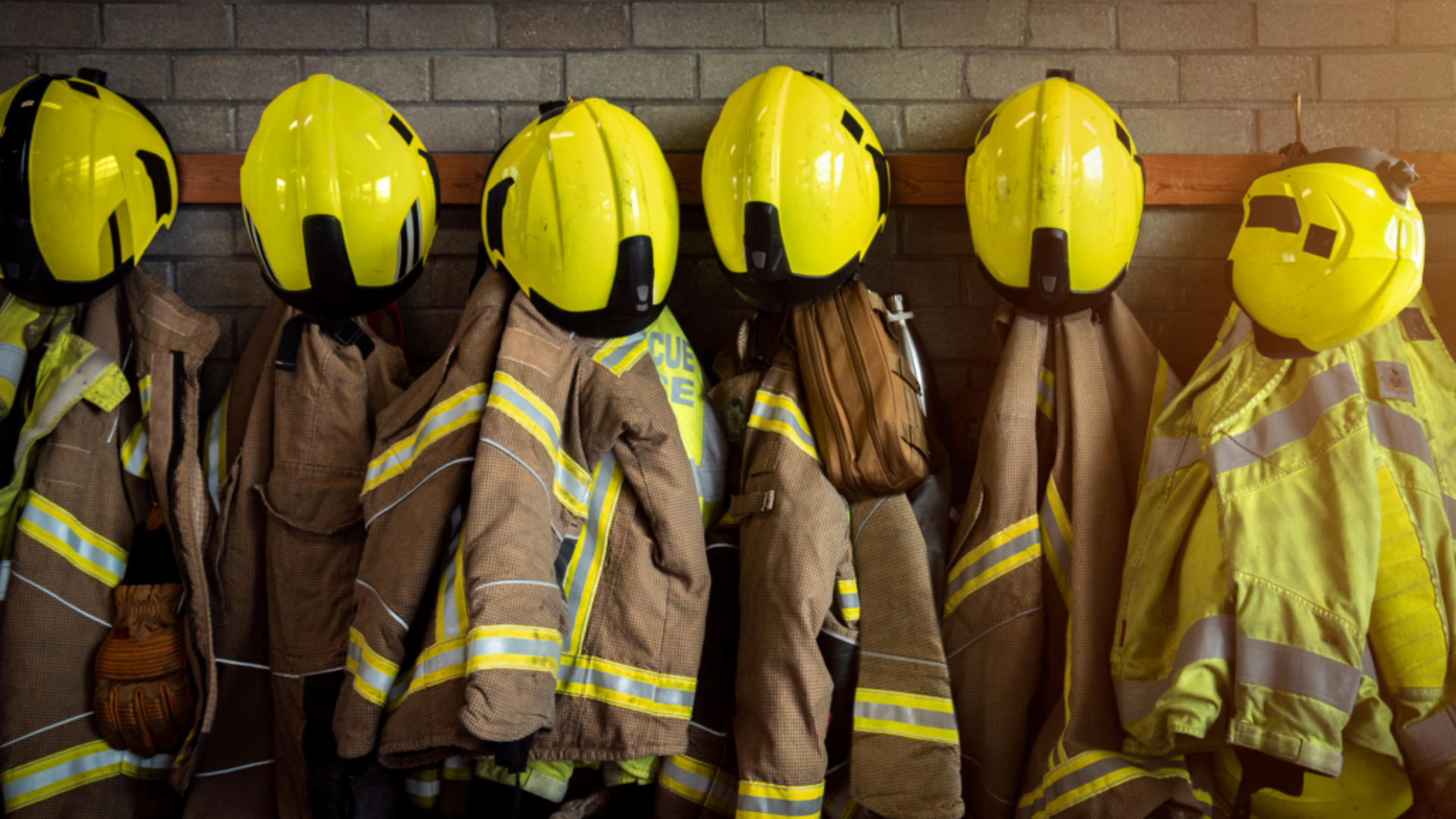 Firefighter helmets and turnout coats hanging in the station